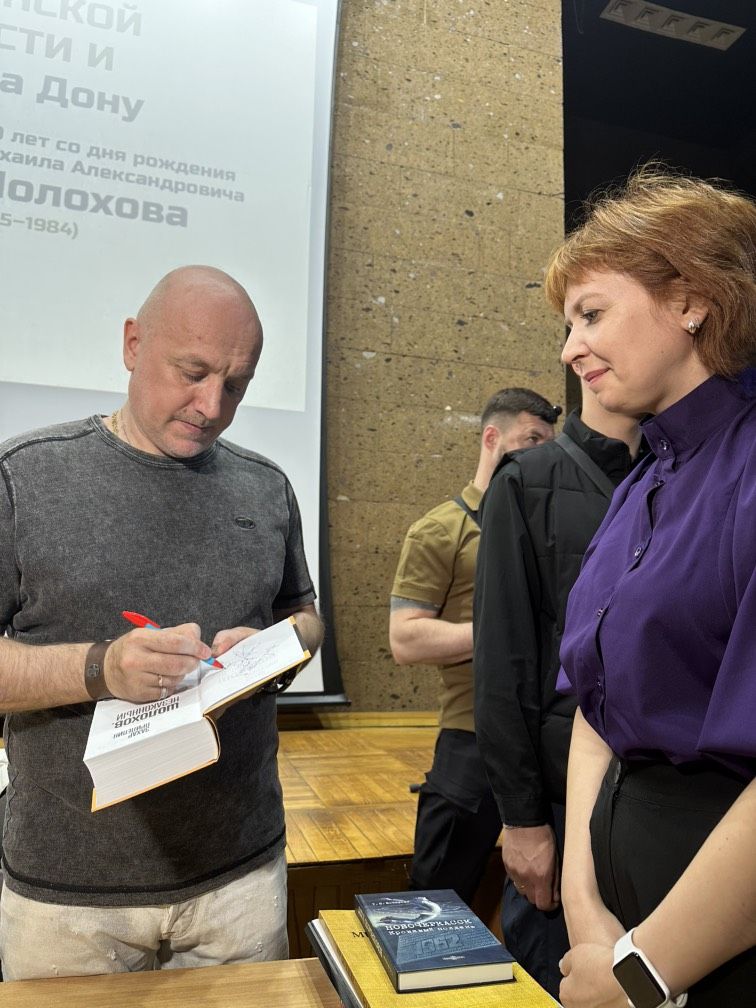 Сотрудники музея берут автограф у З.Прилепина на встрече в ДГПБ, 22.05.2025 г.